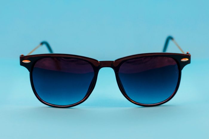 Close-Up Of Sunglasses Over Blue Background