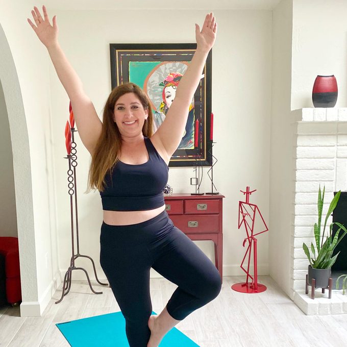 woman doing yoga in leggings on a yoga mat in her living room