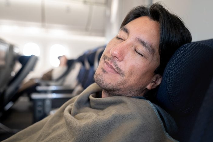 Man traveling by plane and sleeping