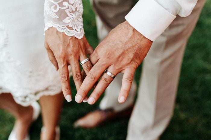 husband and wife holding hands showing their wedding rings