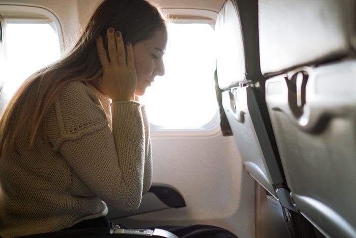 Woman Suffering From Airsickness In Airplane