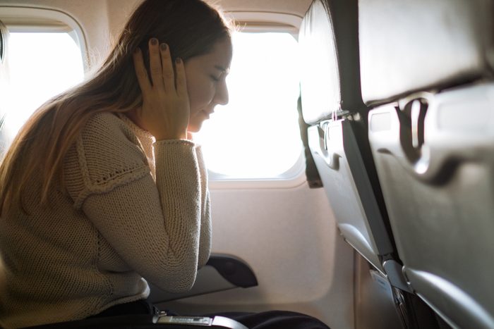 Woman Suffering From Airsickness In Airplane