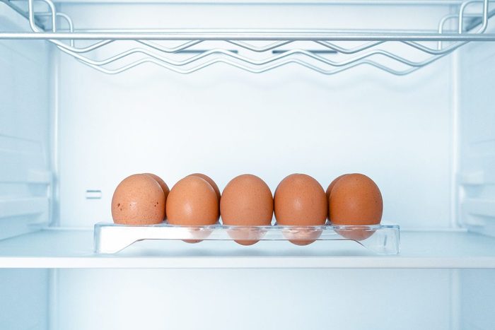 Somes eggs inside a cold and empty fridge