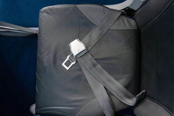 Overlap seat belts on airplane chair top view no people