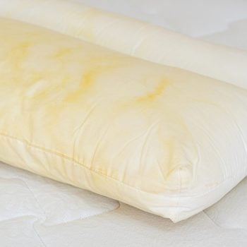 Pillow with yellow stains atop a mattress