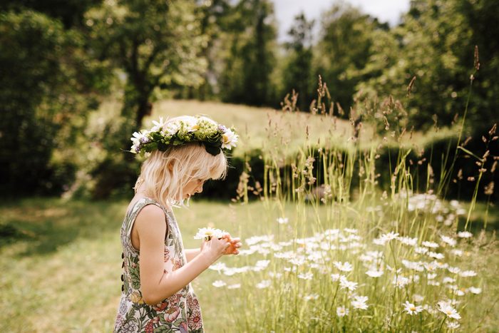 Girl wearing flower wreath in a field