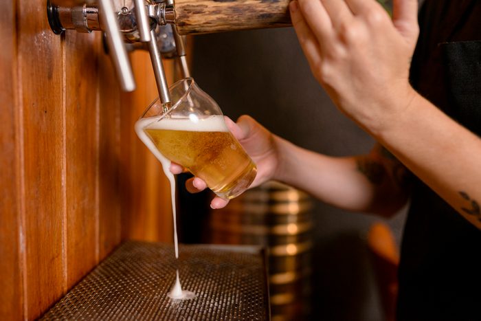 Detail of hands serving beer in brewery
