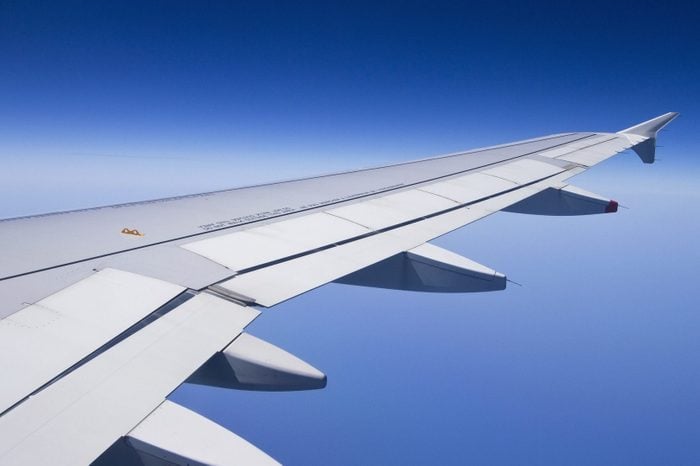 The wing of an airplane with a clear blue sky