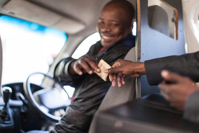 African businessman paying the taxi driver
