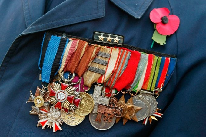 former serviceman wears his medals and a poppy as he prepares to march past The Cenotaph in Whitehall during the annual Remembrance Day service and parade