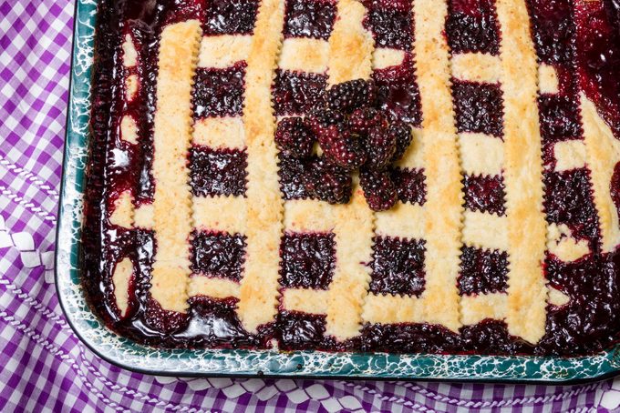 pan of Marionberry cobbler with crossed crust on a checkered background