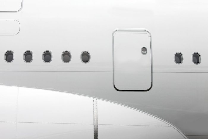 Jet airplane windows and cabin door from outside, white fuselage