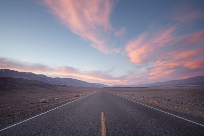 straight road in desert at sunset