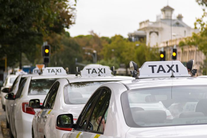 White taxi cars parking along the footpath in Adelaide, Australia