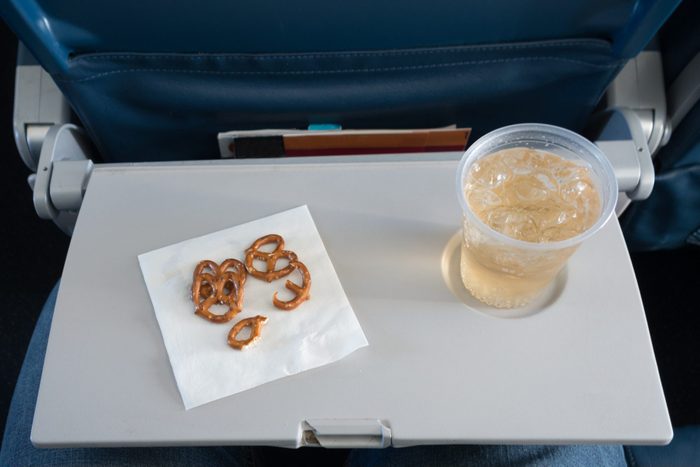 airplane tray with pretzels and drink