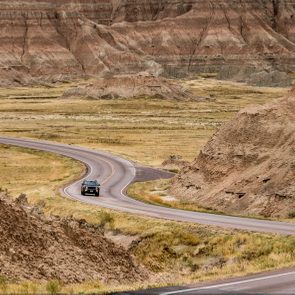 Car Driving along winding road, Badlands National Park, South Dakota, America, USA