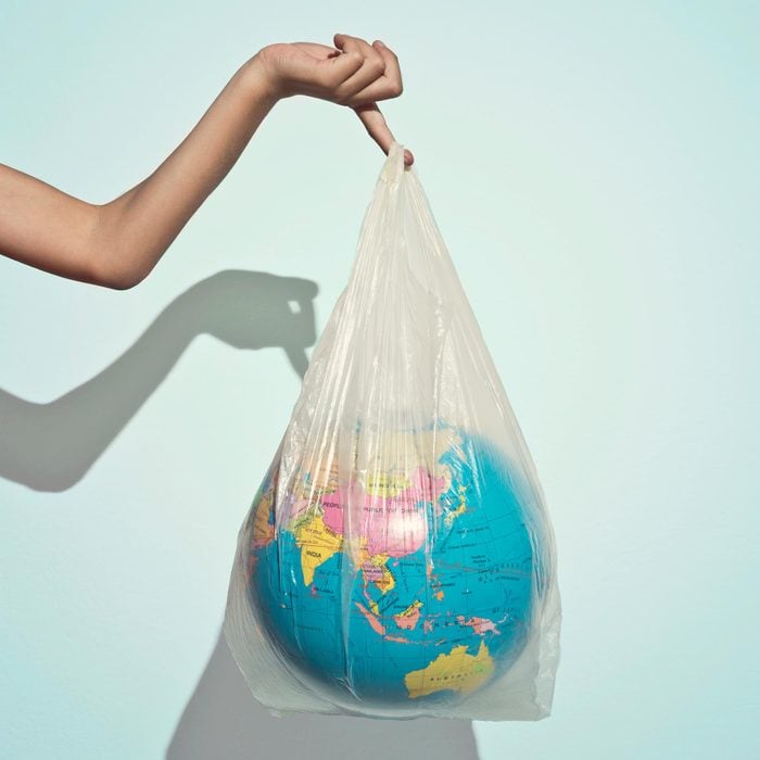 hand holding plastic bag with globe