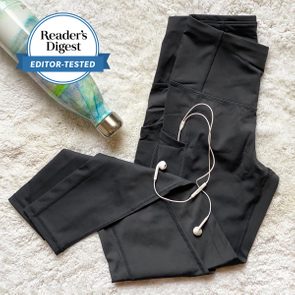 black leggings arranged with earbud headphones and a water bottle