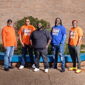 Five members of Dads on Duty standing in front of Southwood High School.