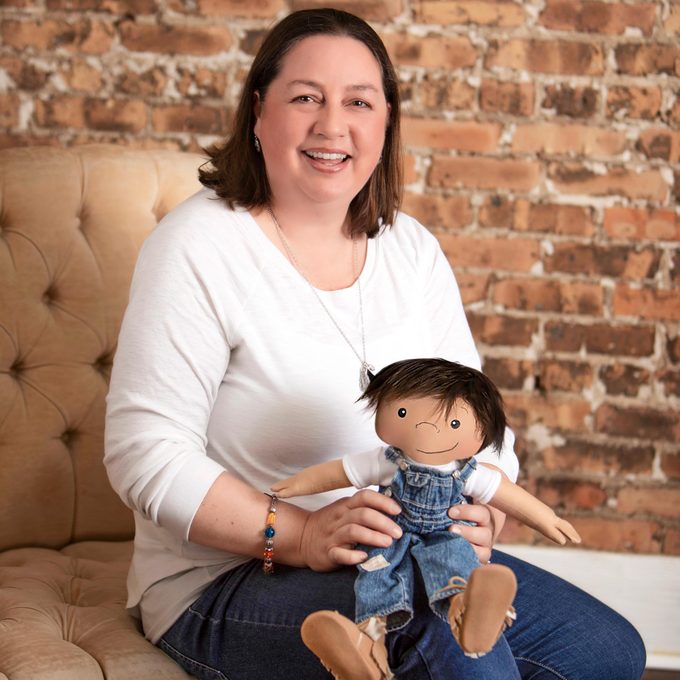 Amy Jandrisevits poses with one of the dolls
