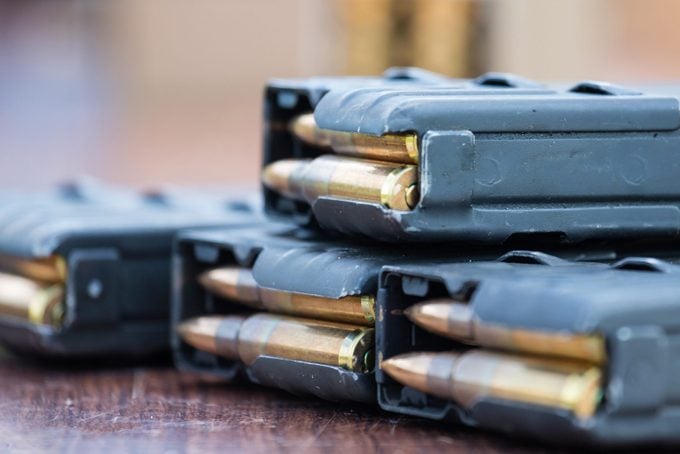 high capacity magazines with bullets on wooden table. Close up