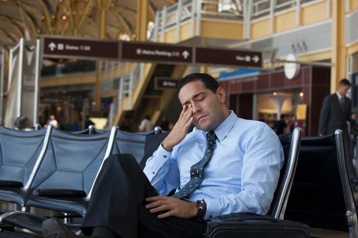 Tired Hispanic business traveler in airport