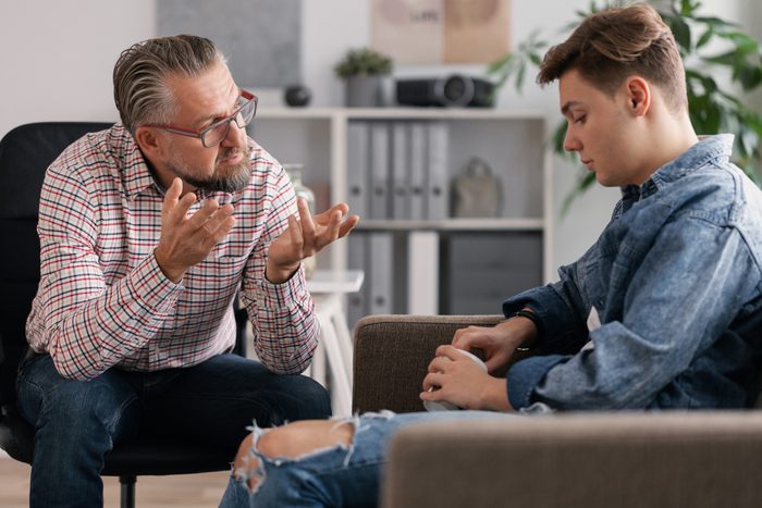 Professional counselor and troubled teenager during therapy meeting