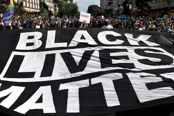 Demonstrators deploy a " Black Lives Matter" banner