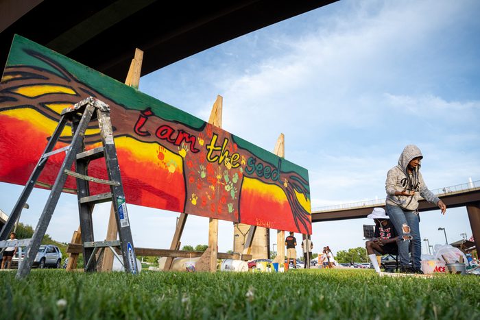 A young woman stands near a piece of art created during the Louisville Juneteenth Festival at the Big Four Lawn on June 19, 2021 in Louisville, Kentucky