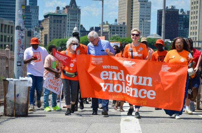 New Yorkers are seen holding End Gun Violence banner while marching across the Brooklyn Bridge on June 4, 2022 to speak up in support of survivors of Texas shooting and gun violence prevention.