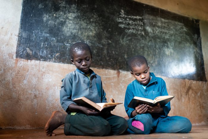 Two African boys with book in school