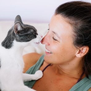 cat licking her happy owner