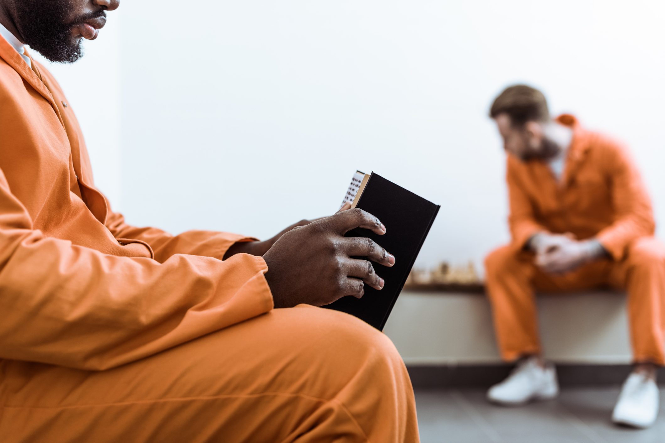 cropped image of african american prisoner reading book