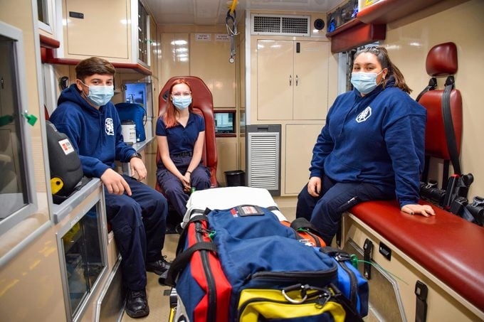 Teen Volunteer Fire Fighters sit in the back of an ambulance