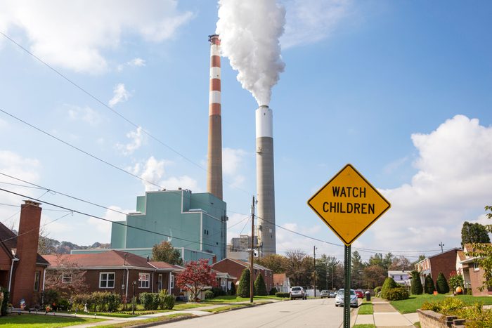 A view of the smoke stacks of the 47-year old Cheswick coal-fired power plant in Springdale, Pennsylvania behind a residential neighborhood with a "Watch Children" sign in the foreground.