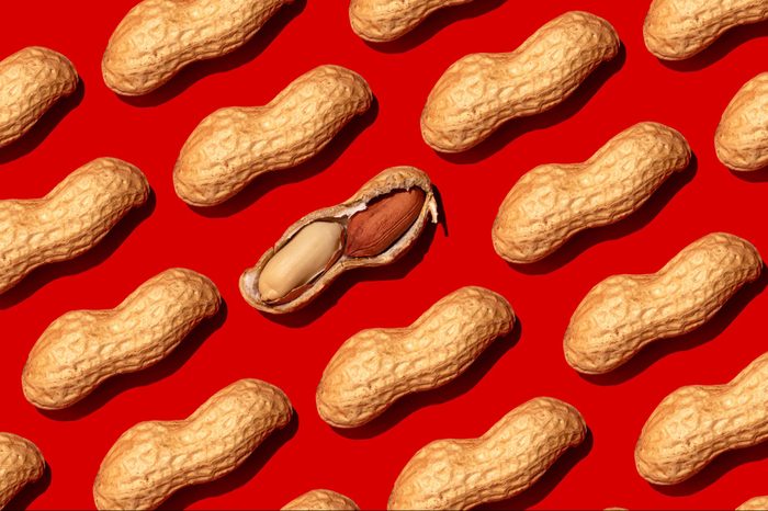 Repeated peanuts ad one halved nut on the red background