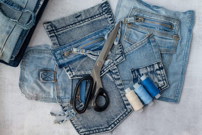 Different jeans pockets, scissors and threads ready to recycle.
