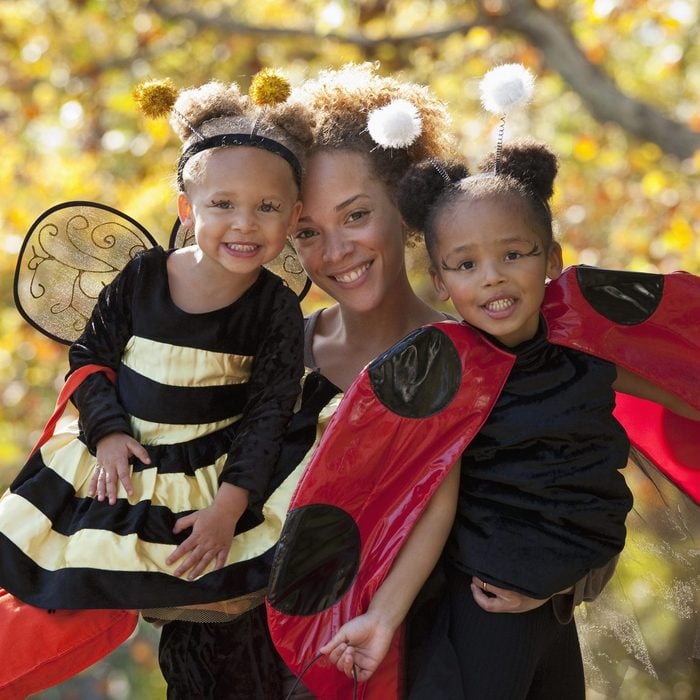 Black mother and daughters in Halloween costumes