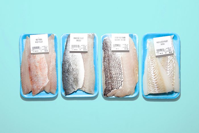 Four fish fillets in packaging on blue background