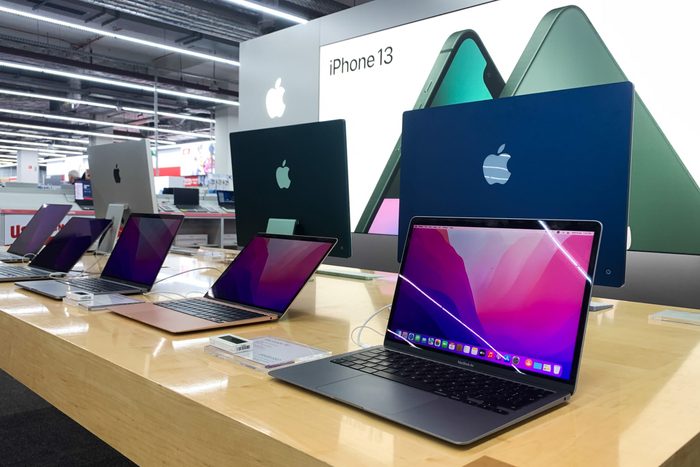 table with Apple laptops in the store
