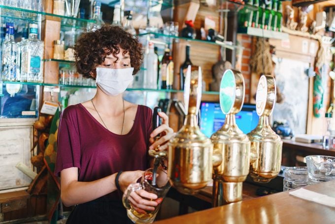 masked bartender filling beer