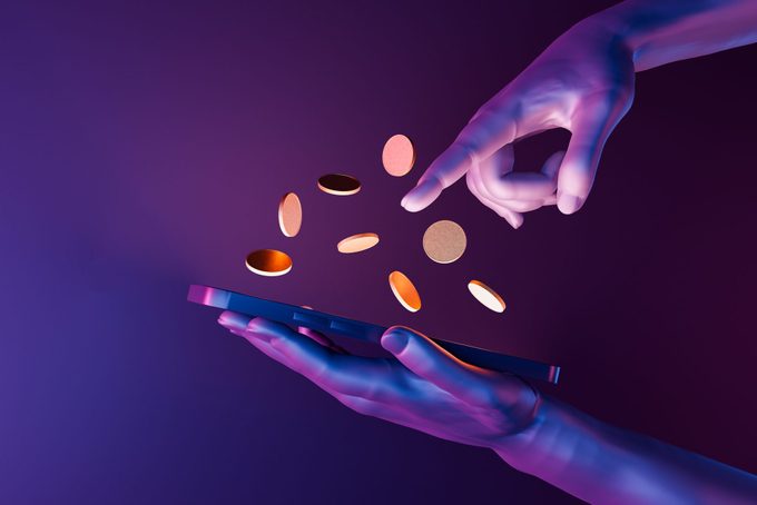 futuristic 3d hands holding a cell phone with coins on the screen with neon lights