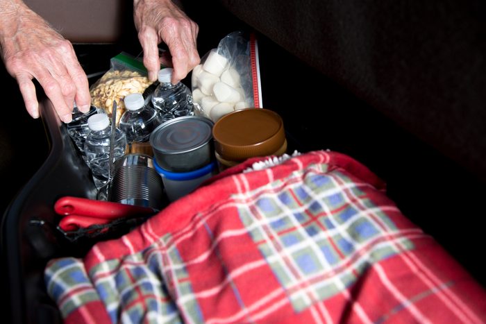 LV Senior man prepares for roadside emergency with survival items in his truck.