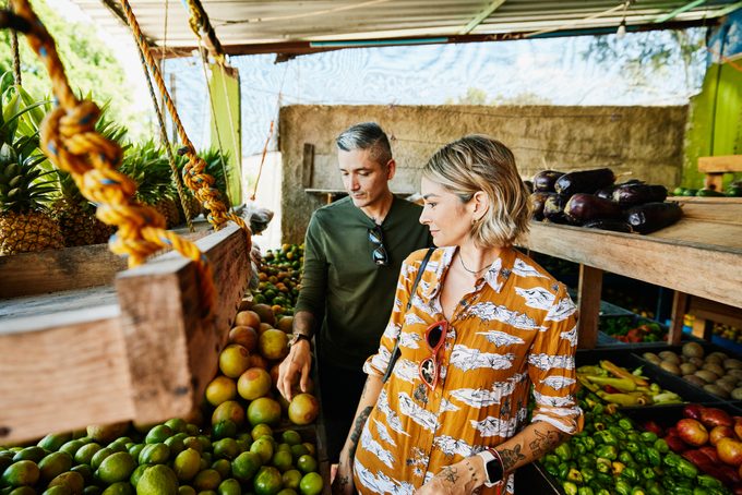 couple shopping at fruit stand while on vacation