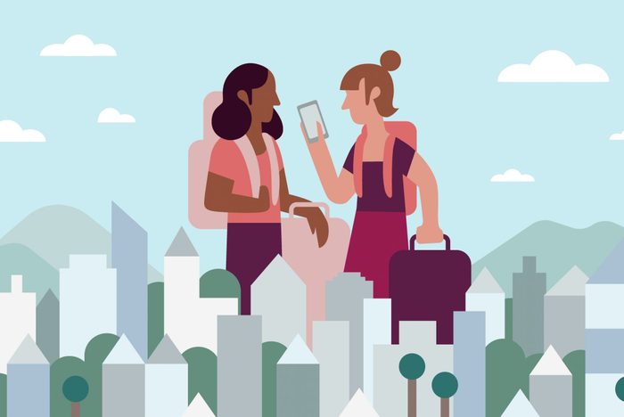 Two Girlfriends Look At Digital Nomad Visa While Traveling In Cityscape Together