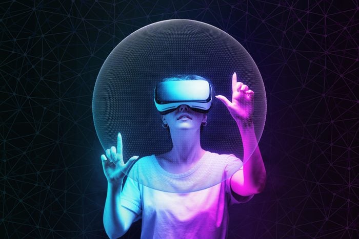 woman in VR glasses creates mesh sphere. Dark background with neon abstracts. The concept of virtual reality and futurism