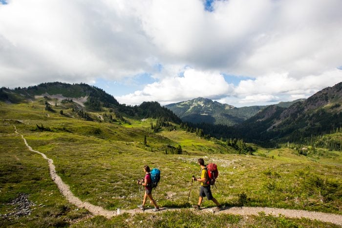 A young couple backpacking along a trail in the Olympic National Park.