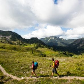 A young couple backpacking along a trail in the Olympic National Park.