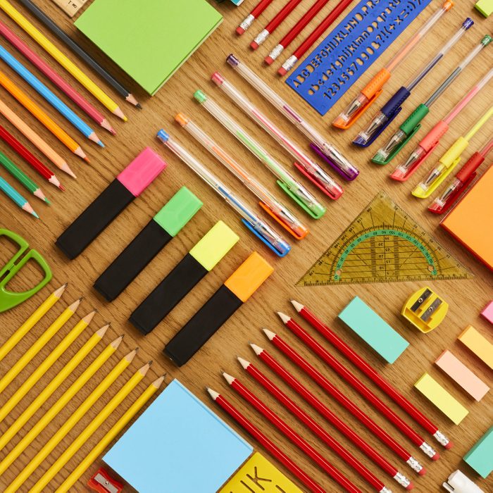 Office and school supplies arranged on wooden table - Knolling