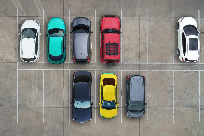 aerial view of a. parking lot with cars and empty spaces